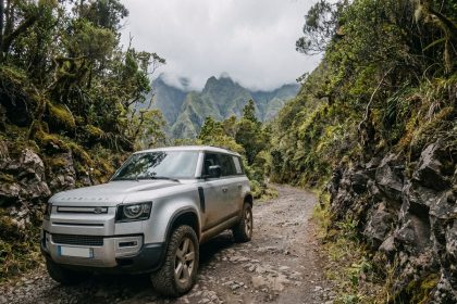 SUV moderne garé sur une route de montagne sinueuse à La Réunion entouré de végétation tropicale et de formations volcaniques